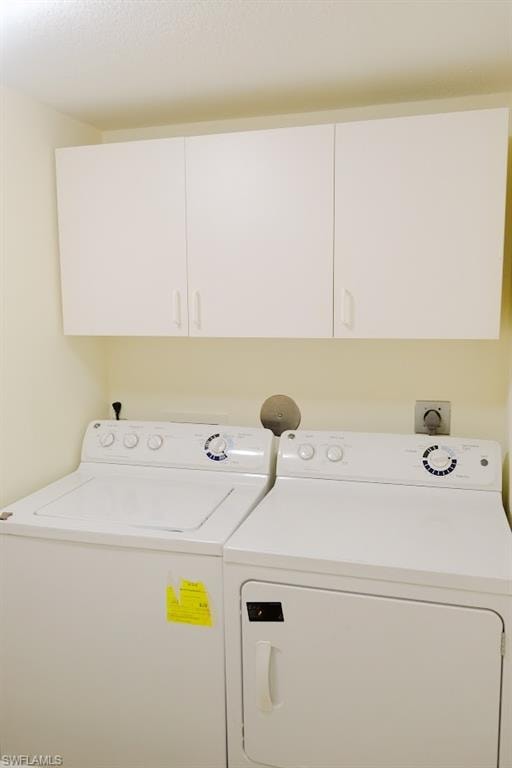 Clothes washing area with cabinets and separate washer and dryer