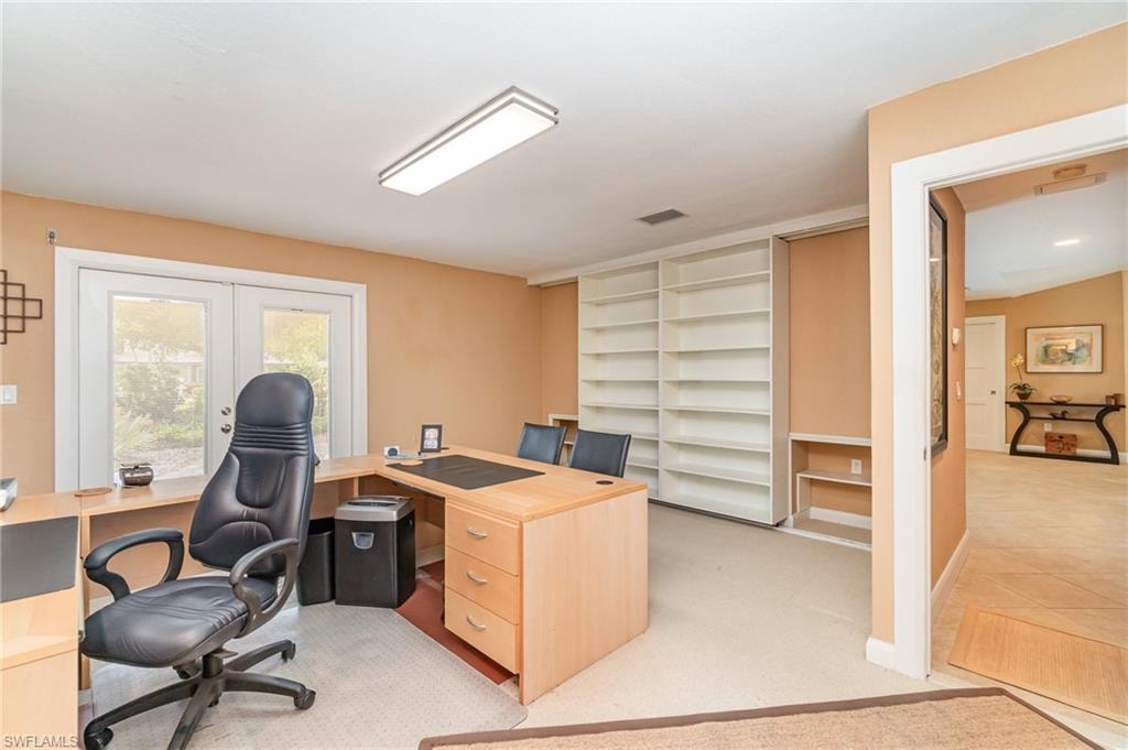 Carpeted office featuring french doors