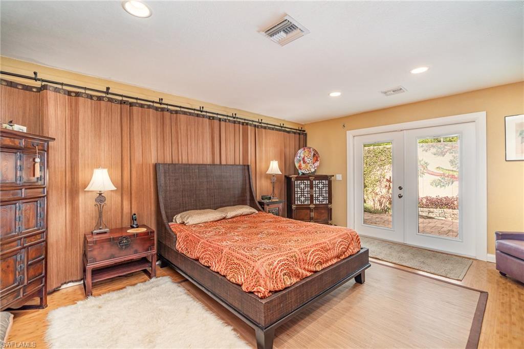 Bedroom with access to exterior, french doors, and wood-type flooring