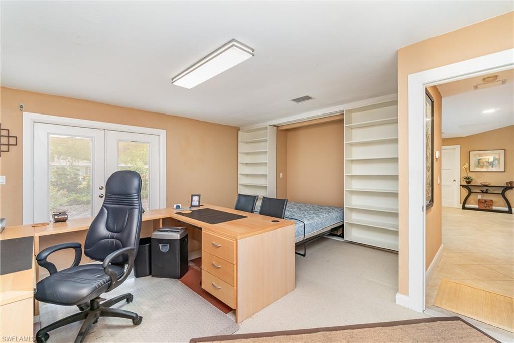 Office area featuring light carpet and french doors