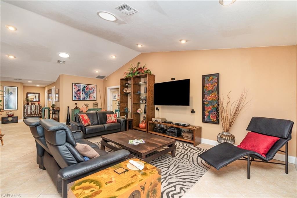 Living room featuring lofted ceiling and light tile floors