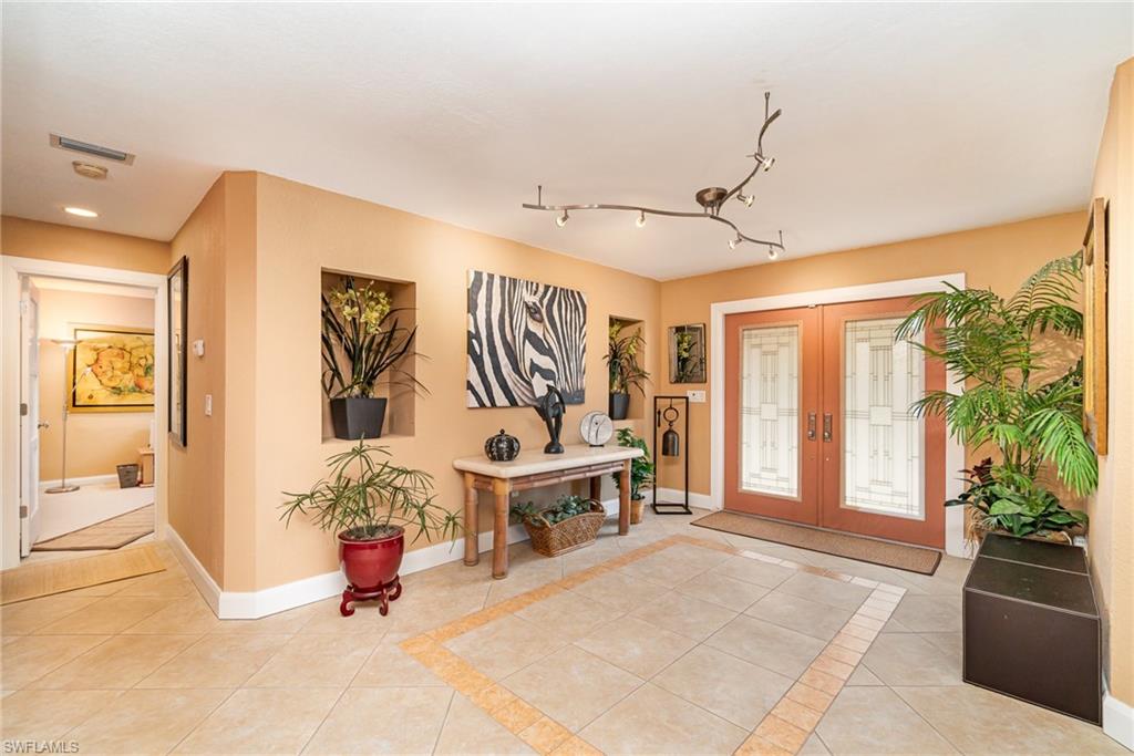 Entrance foyer with french doors, light tile floors, and rail lighting