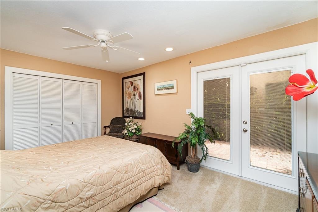 Bedroom featuring french doors, a closet, access to exterior, carpet flooring, and ceiling fan