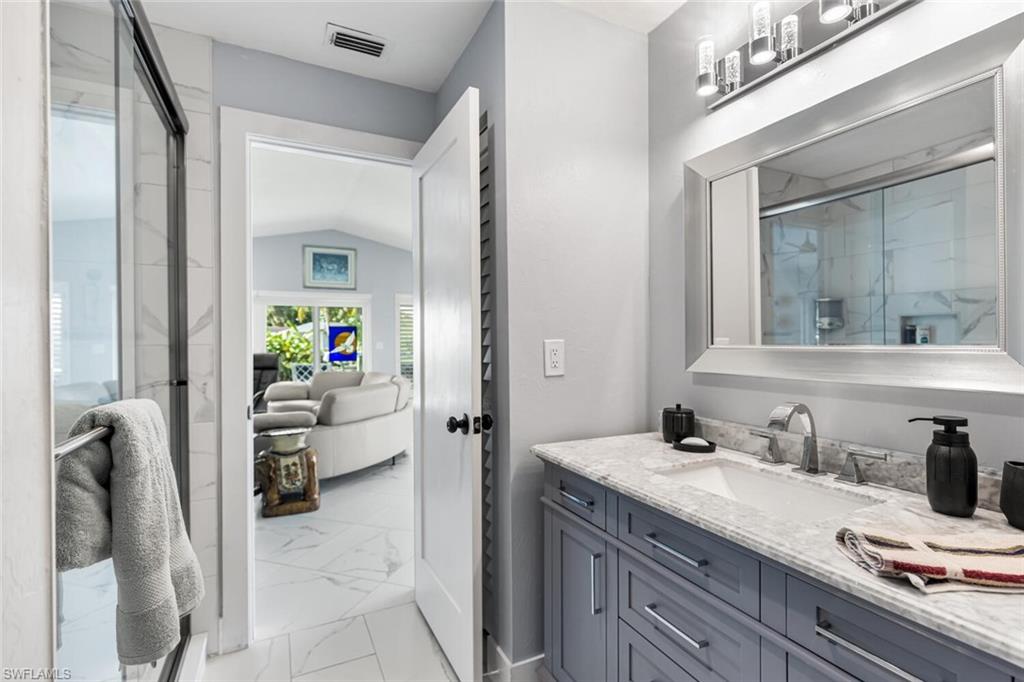 Guest bath is adjacent to Guest Bedroom just off of Living Room.  Quartz counter top vanity and shower.