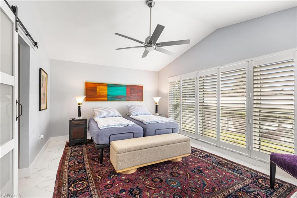 Large Owner's Suite with windows to the canal side of the home.  Suite has separate door to patio.  Sliding door leads to full bathroom with walk-in closet.