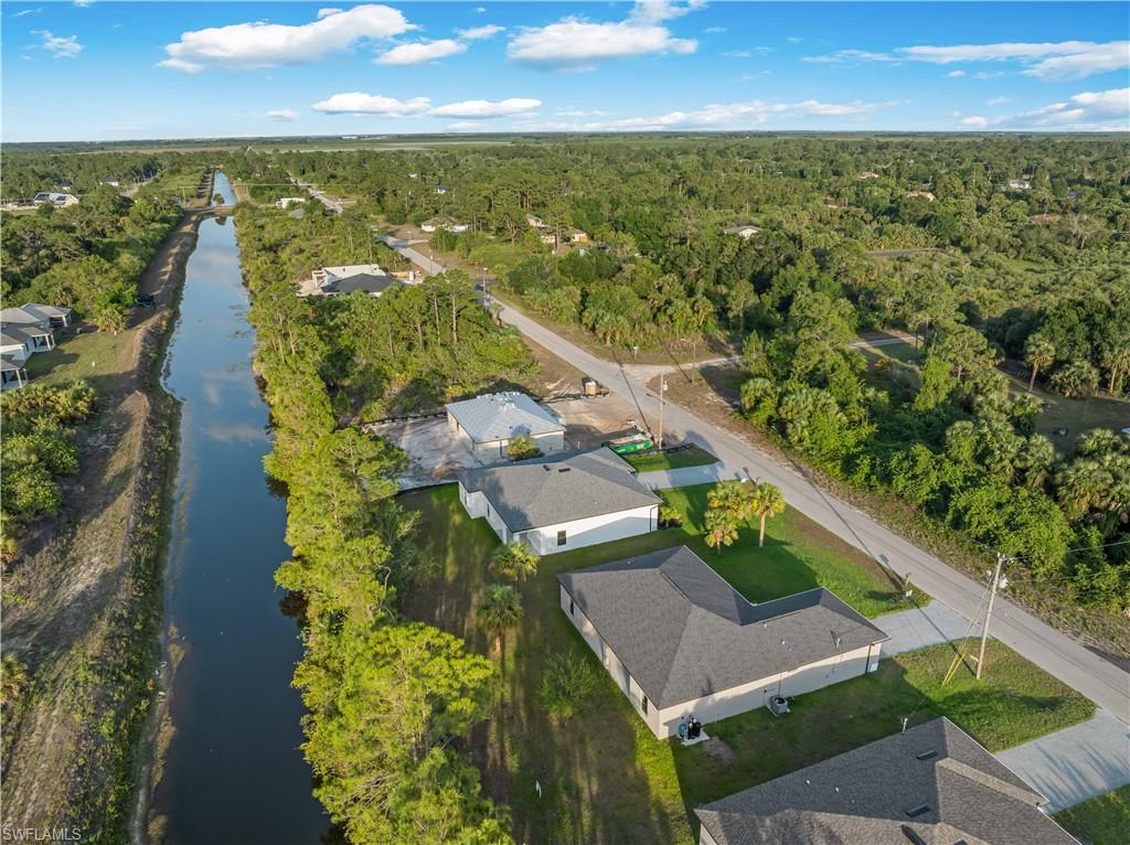 View of property location with a heavily wooded area and a nearby body of water