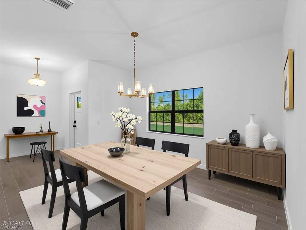 Virtually staged Dining space with wood tiled floors and a chandelier