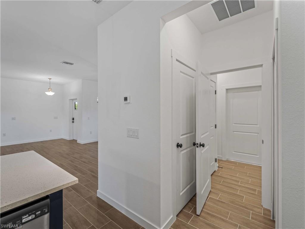 Hallway featuring wood tiled floors and baseboards