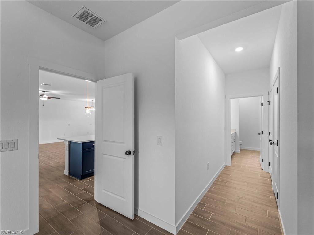 Hallway with wood finish floors and baseboards