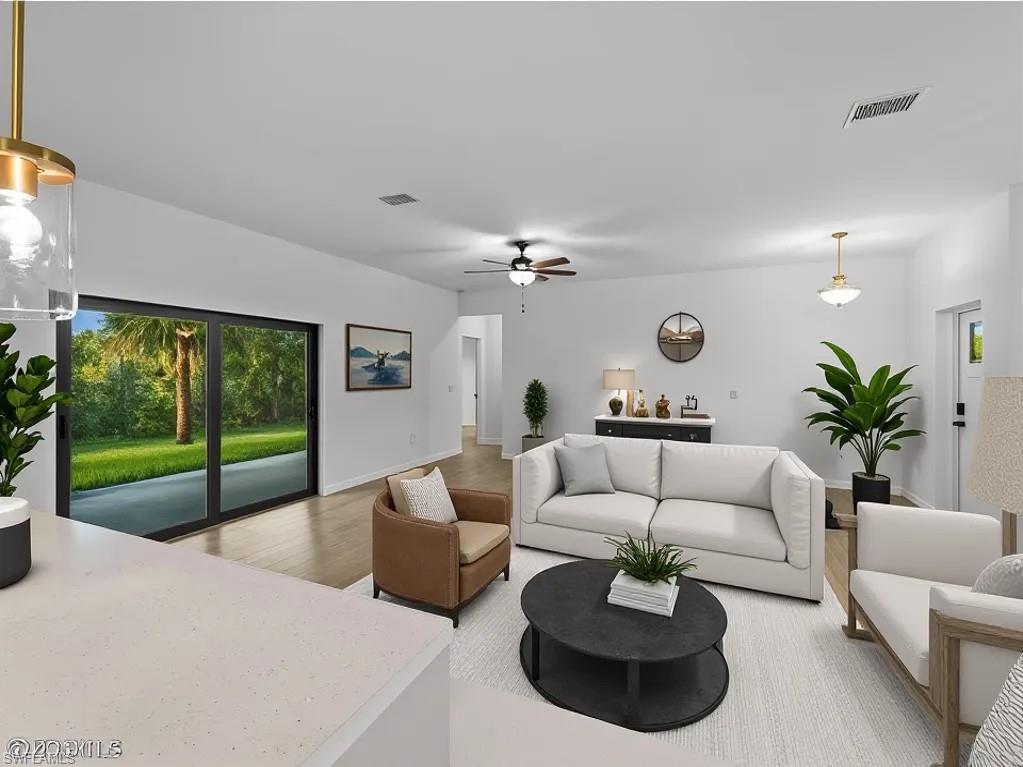 Virtually staged Living area with light wood-type flooring and a ceiling fan