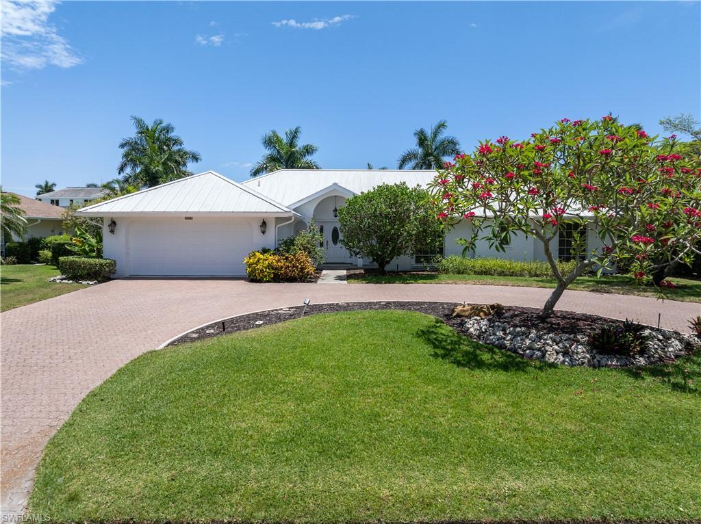 Single story home featuring a garage and a front lawn