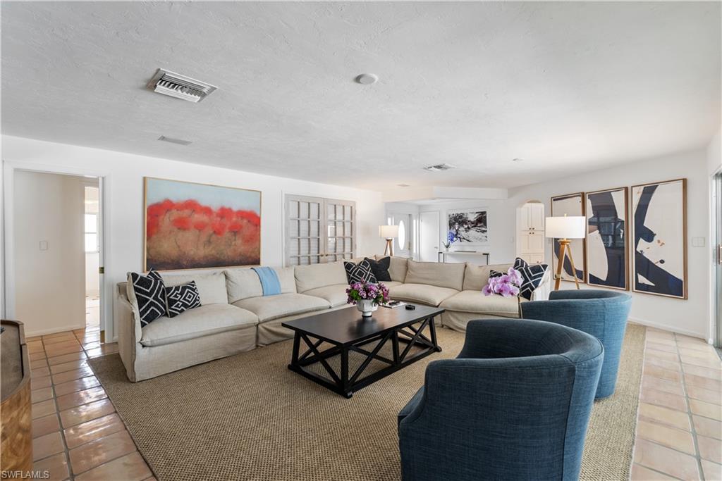 Living room featuring a textured ceiling and light tile floors