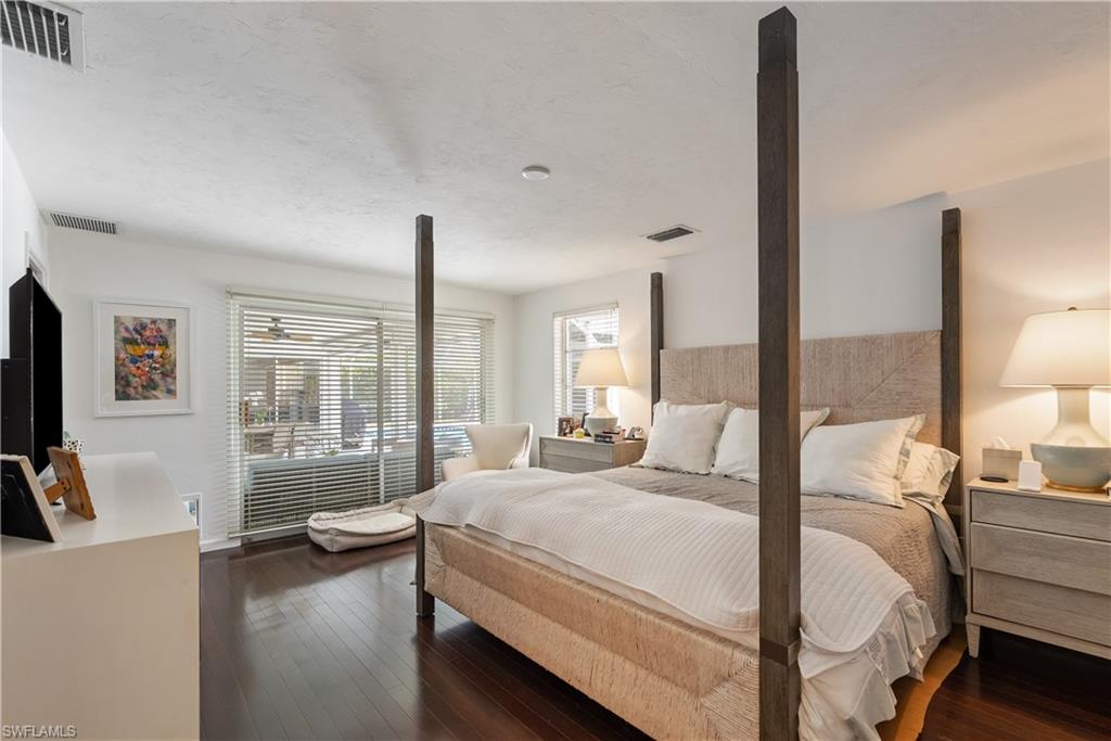 Bedroom with dark hardwood / wood-style flooring
