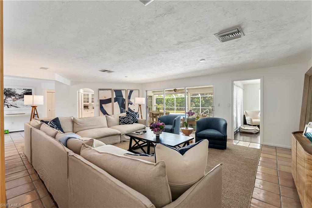 Living room with a textured ceiling and light tile flooring