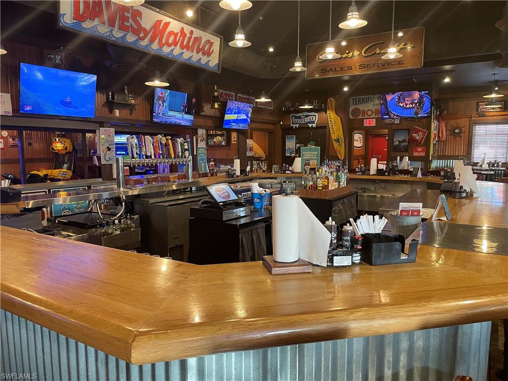 Bar featuring hardwood / wood-style floors and pendant lighting