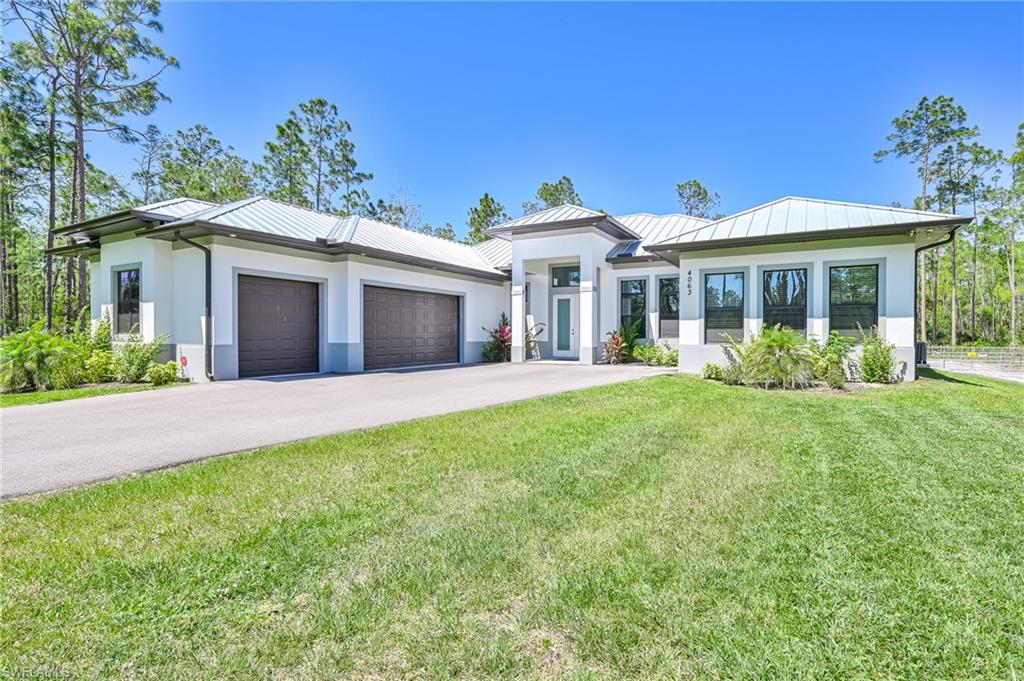 View of front of home featuring a front lawn and a garage