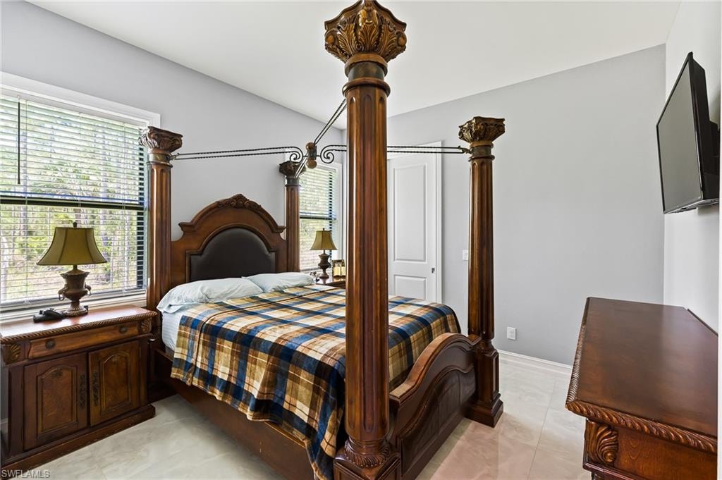 Bedroom with multiple windows and light tile floors