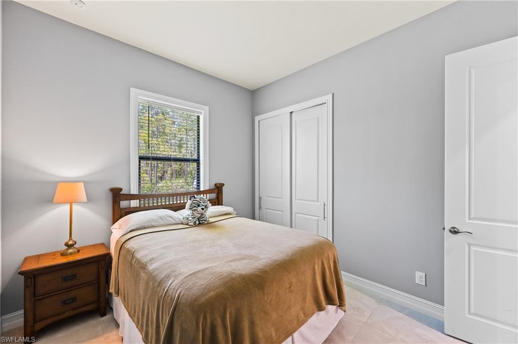 Tiled bedroom featuring a closet