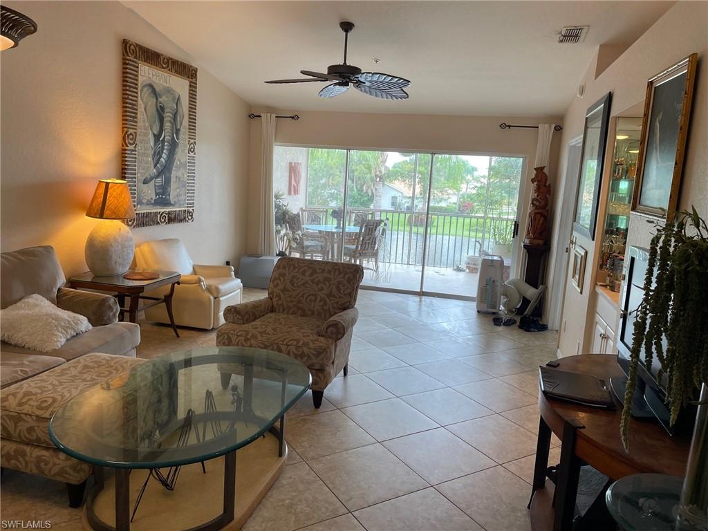 Living room with ceiling fan and light tile flooring