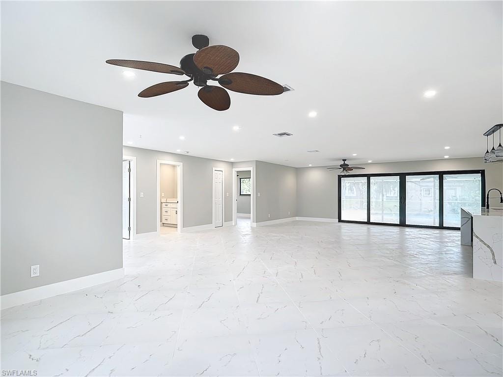 Empty room with sink, ceiling fan, and light tile floors