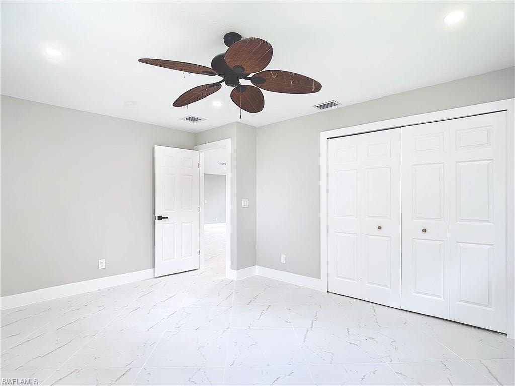Unfurnished bedroom featuring a closet, ceiling fan, and light tile floors