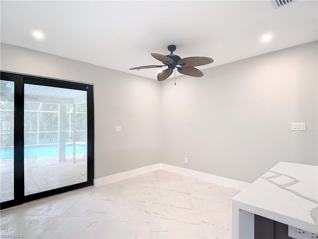 Unfurnished room with ceiling fan and light tile floors