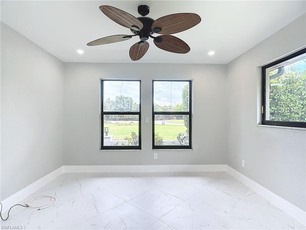 Unfurnished room featuring a healthy amount of sunlight, light tile flooring, and ceiling fan