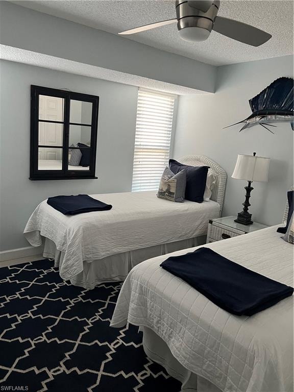 Bedroom with ceiling fan, a textured ceiling, and carpet floors