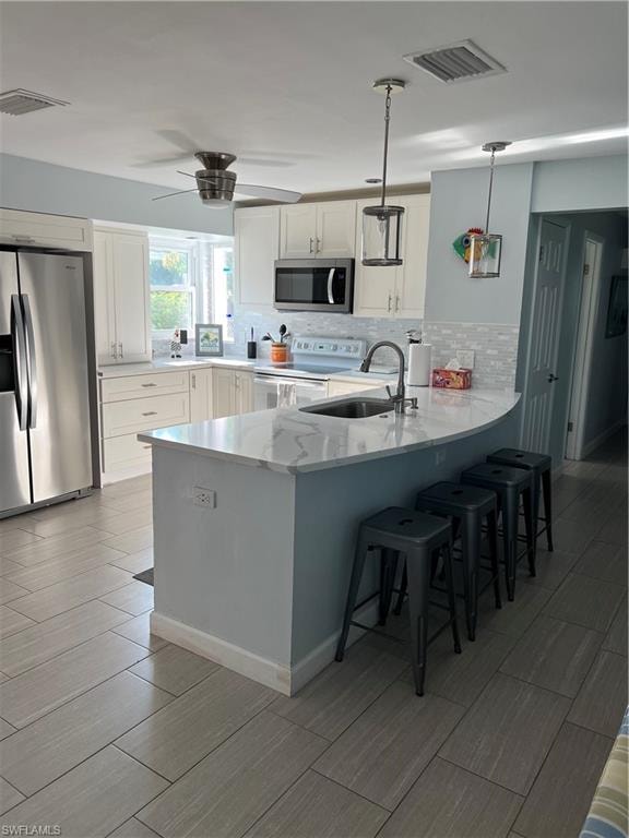Kitchen featuring decorative light fixtures, decorative backsplash, white range with electric stovetop, white cabinetry, and fridge