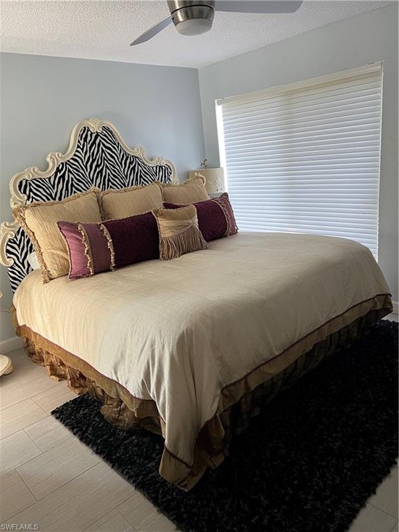 Bedroom with ceiling fan and a textured ceiling