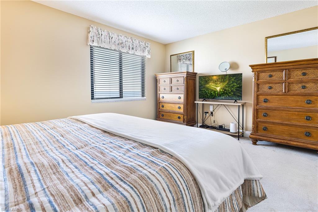 Bedroom with a textured ceiling and carpet