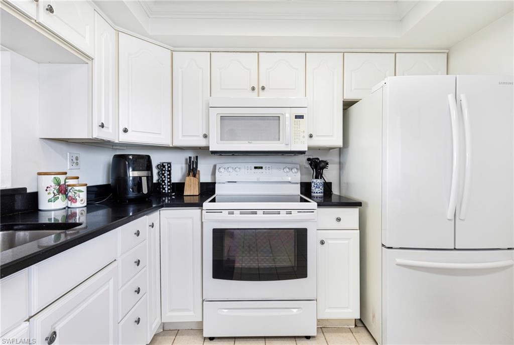 Kitchen featuring white cabinets, white appliances, and crown molding
