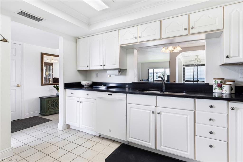 Kitchen with white cabinets, sink, dishwasher, and crown molding