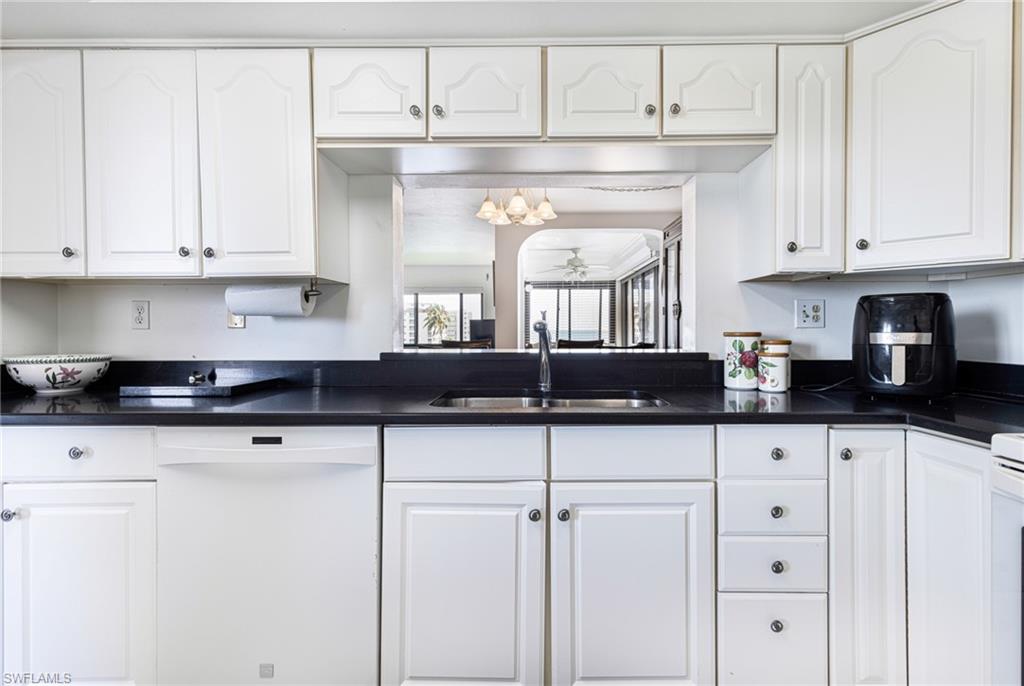 Kitchen with white cabinets, dishwasher, and sink