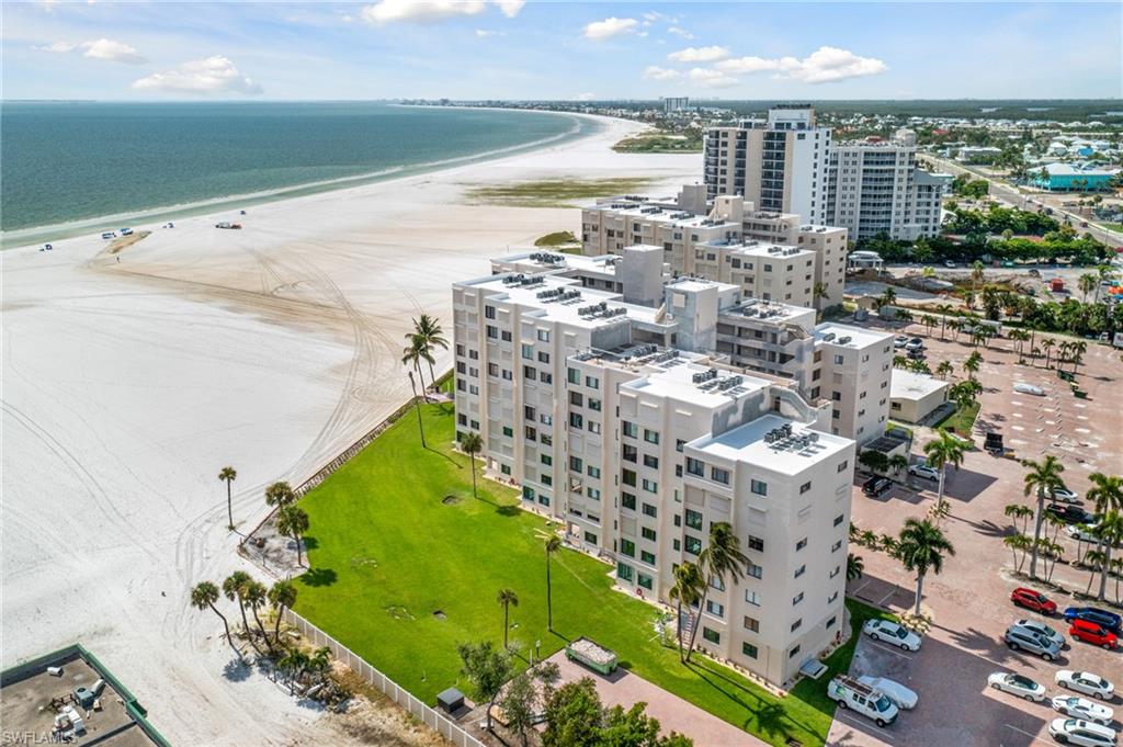 Birds eye view of property featuring a water view and a beach view