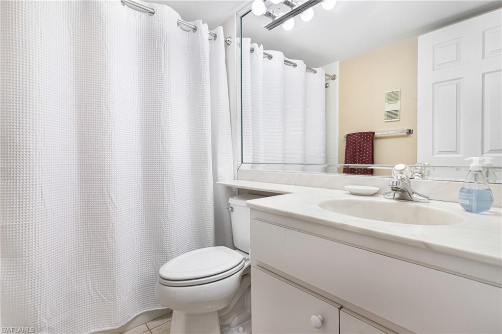 Bathroom featuring vanity, tile patterned flooring, and toilet