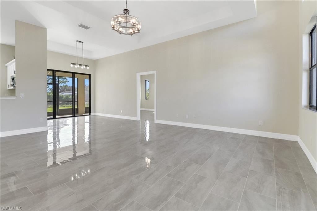 Unfurnished living room featuring an inviting chandelier
