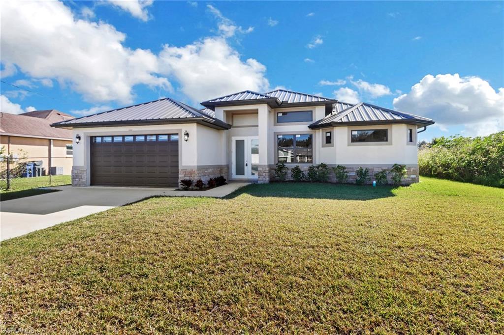 View of front of house featuring a front yard and a garage