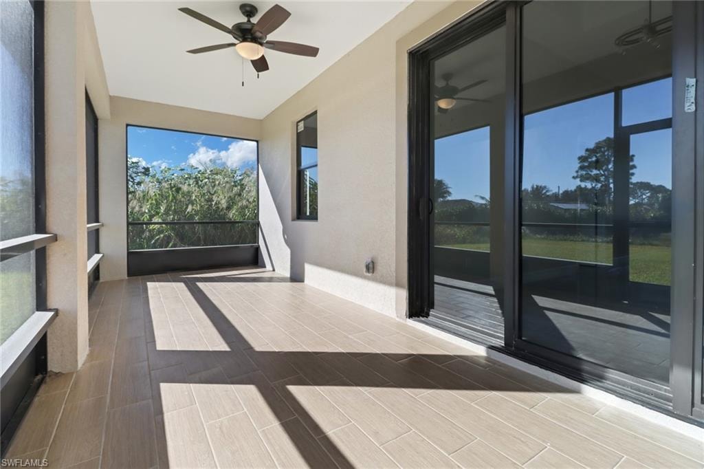 Unfurnished sunroom featuring ceiling fan