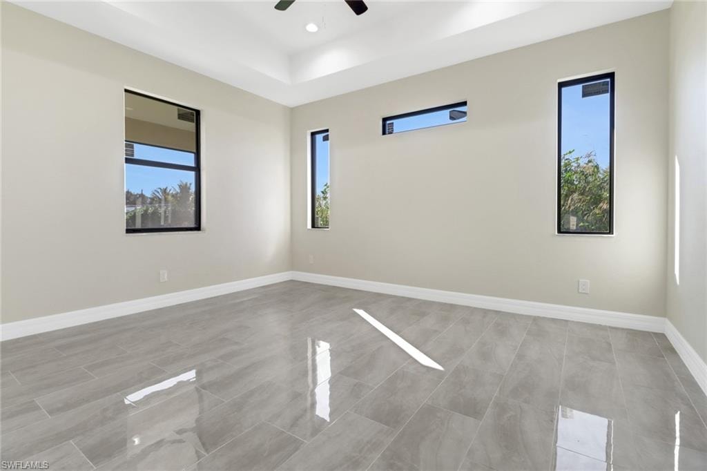 Unfurnished room with ceiling fan and a wealth of natural light