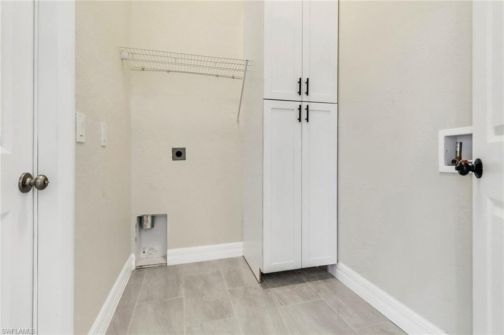 Washroom featuring washer hookup, electric dryer hookup, and cabinets