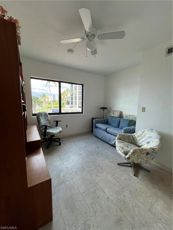 Living room featuring ceiling fan and light tile patterned floors