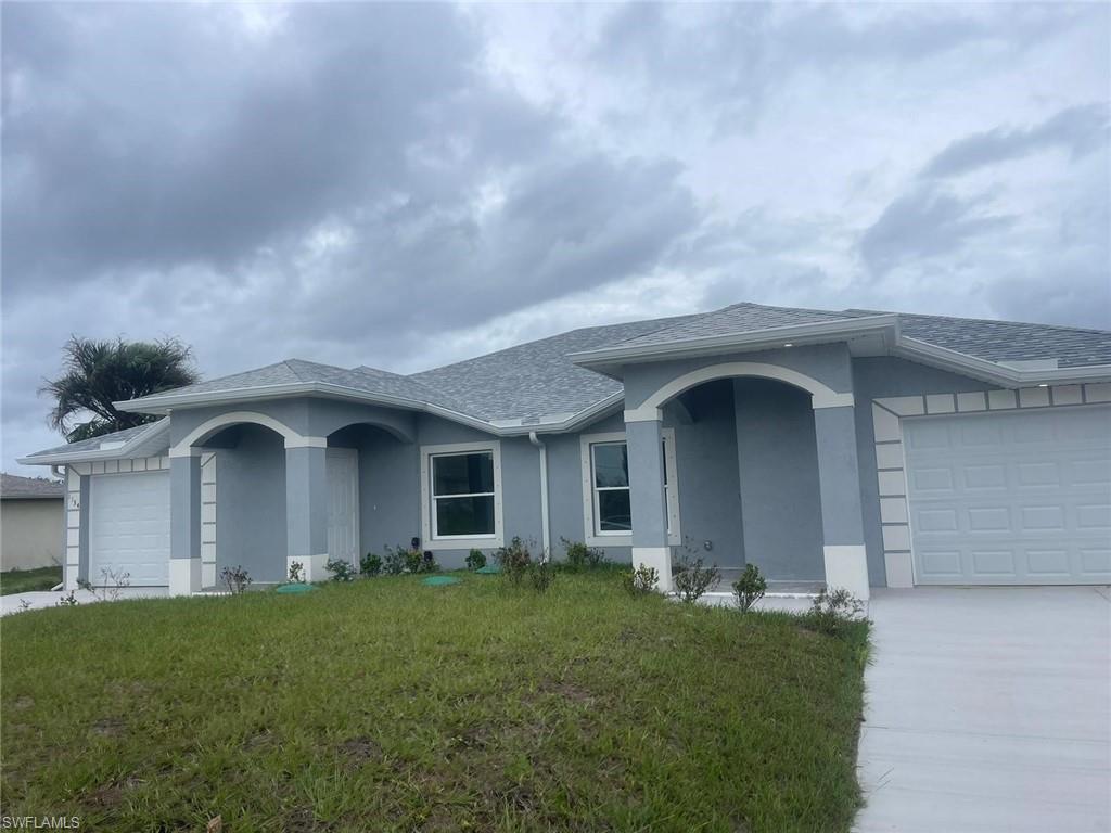 Single story home with a garage and a front yard