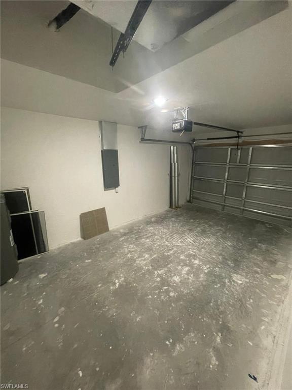 Garage featuring electric panel and a garage door opener