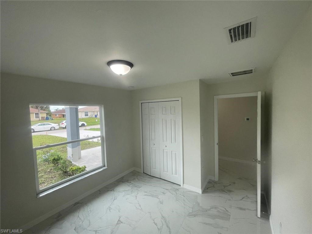 Unfurnished bedroom featuring a closet and multiple windows