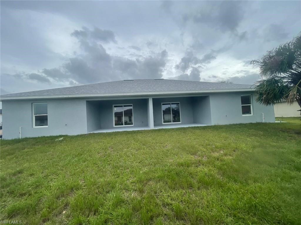 Back of property featuring a lawn