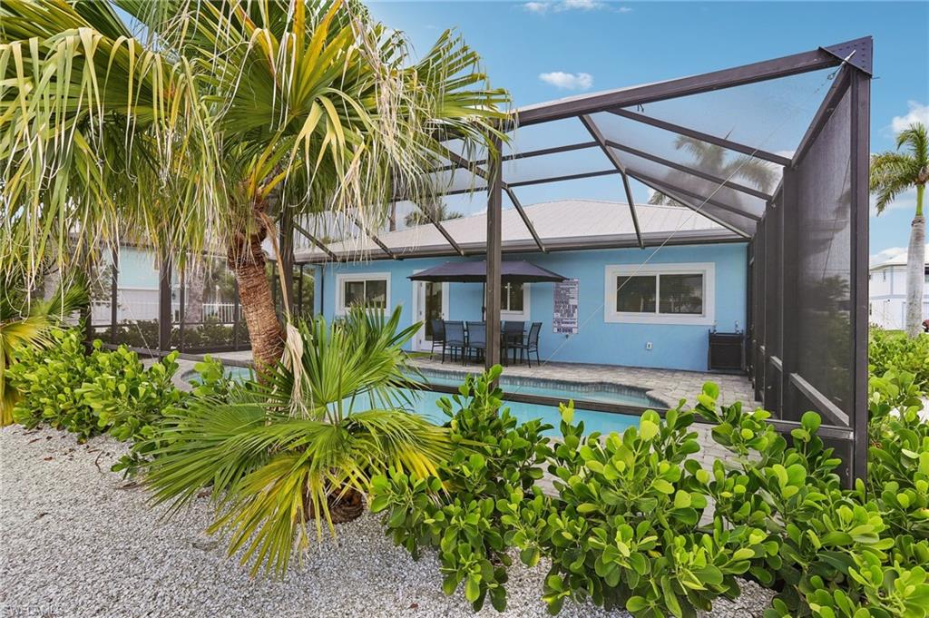 Rear view of house with a patio area and glass enclosure