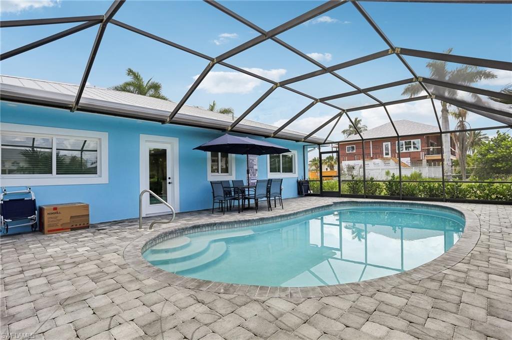 View of pool featuring a patio, french doors, and glass enclosure