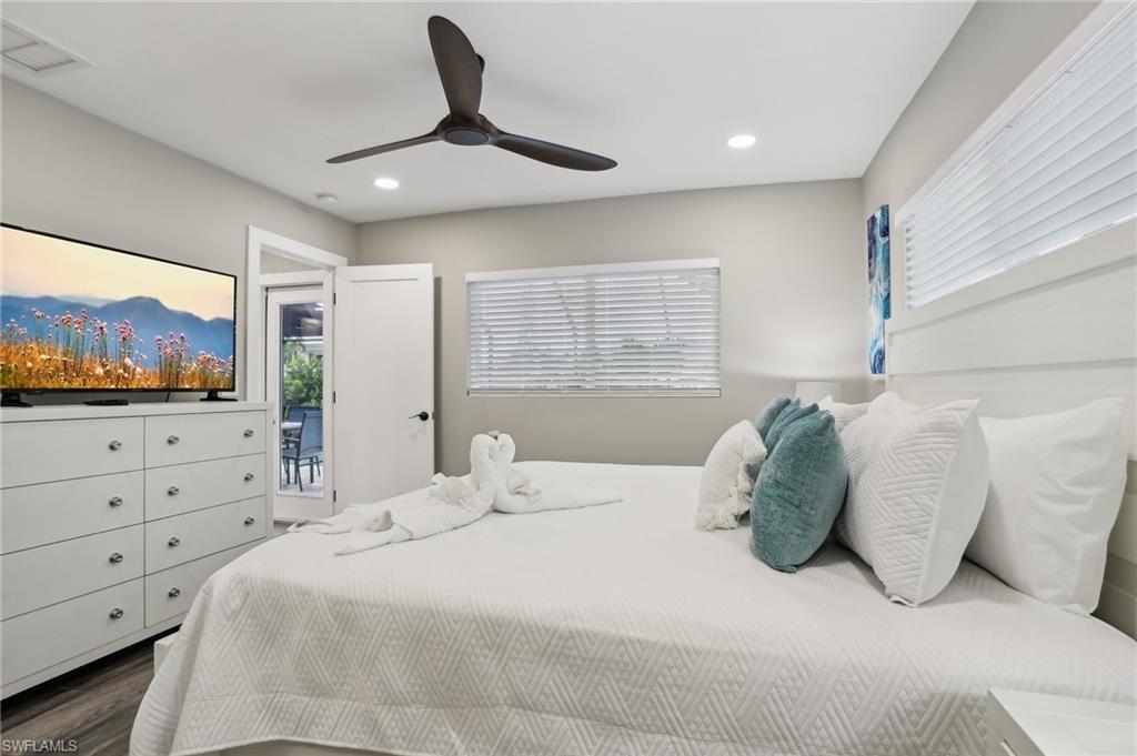 Bedroom featuring hardwood / wood-style flooring, ceiling fan, and access to exterior