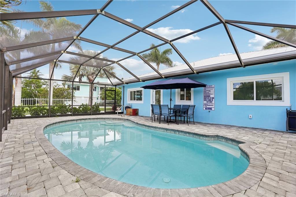 View of pool with a patio and glass enclosure